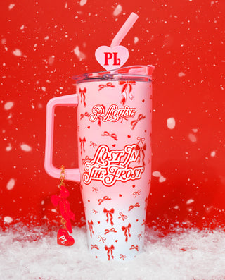 Pink P.Louise Christmas Frost Cup in adult size with 'P. Louise' branding and red ribbon design on a red background surrounded by snow