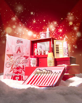 P.Louise Miniwood Vanity Gift Set containing mini makeup and cosmetic products with a mirror in the packaging on a red background surrounded with snow
