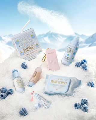Collection of blue raspberry Pack Your Shit And Go skincare products on a snowy background with blue raspberries.